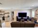 Comfortable living room with entertainment center, leather seating and views into the kitchen and secondary rooms at 415 Seville Ave, Altamonte Springs, FL 32714