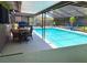 Enclosed pool area featuring clear blue water, dining set, grill, and lounge chairs at 415 Seville Ave, Altamonte Springs, FL 32714