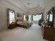 Comfortable main bedroom featuring tray ceiling, large window and carpet flooring at 4906 Keaton Crest Dr, Orlando, FL 32837