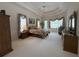 Bright main bedroom featuring tray ceiling, large window and carpet flooring at 4906 Keaton Crest Dr, Orlando, FL 32837