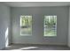 Bright bedroom featuring two windows with views of the lush, green yard at 5153 Sw 159Th St, Ocala, FL 34473