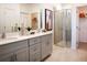 Bathroom featuring a double-sink vanity, modern fixtures, a glass-enclosed shower, and access to a spacious walk-in closet at 519 Silver Palm Dr, Haines City, FL 33844