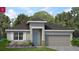 Charming single-story home featuring a two-car garage, blue door, and beautifully landscaped front yard at 519 Silver Palm Dr, Haines City, FL 33844