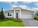 Charming single-story home featuring a 2-car garage, gray facade, neatly manicured lawn and garden, and inviting entryway at 519 Silver Palm Dr, Haines City, FL 33844
