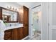 Bathroom with natural wood cabinets, white quartz countertops, and updated shower at 525 Southport Dr, Longwood, FL 32750