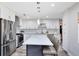 Modern kitchen with stainless steel appliances, quartz countertops, a center island, and ample cabinet space at 525 Southport Dr, Longwood, FL 32750