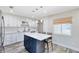 Updated kitchen featuring white cabinetry, stainless steel appliances, a center island with seating, and luxury vinyl flooring at 525 Southport Dr, Longwood, FL 32750