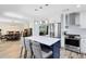 Bright kitchen featuring white cabinets, a blue island with seating, stainless steel appliances, and open access to dining at 525 Southport Dr, Longwood, FL 32750