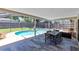 Relaxing screened-in pool area with a spa and an outdoor dining set on a tiled patio at 525 Southport Dr, Longwood, FL 32750
