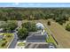 Beautiful aerial view of a home with a screened pool, well-maintained landscaping, and proximity to a wooded area at 548 Casterton Cir, Davenport, FL 33897