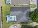 An aerial view of the roof, screened-in pool, and well-manicured lawn of a single-Gathering home at 548 Casterton Cir, Davenport, FL 33897