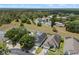 An aerial view of the home in a well-maintained community, showing lush landscaping and nearby wooded areas at 548 Casterton Cir, Davenport, FL 33897