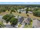 An aerial view of the home in a well-maintained community, showing lush landscaping and nearby wooded areas at 548 Casterton Cir, Davenport, FL 33897
