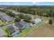 An aerial view of the home in a well-maintained community, showing lush landscaping, screened pool and wooded areas at 548 Casterton Cir, Davenport, FL 33897