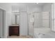 Bright bathroom with granite vanity, closet, glass shower, and soaking tub under a window at 548 Casterton Cir, Davenport, FL 33897