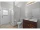 Bright bathroom features tile floor, a glass shower, a toilet and a vanity with cherry cabinets at 548 Casterton Cir, Davenport, FL 33897