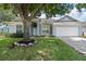 Welcoming one-story home featuring a light-blue facade, an attached two-car garage and landscaped garden at 548 Casterton Cir, Davenport, FL 33897