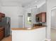 Kitchen featuring stainless steel refrigerator, breakfast bar, and wood cabinets at 548 Casterton Cir, Davenport, FL 33897