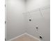 Clean and functional laundry room with tile flooring, storage shelving, and utility hookups at 548 Casterton Cir, Davenport, FL 33897