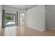 Neutral living room featuring tile floors, sliding glass doors, and an arched entryway to other rooms at 548 Casterton Cir, Davenport, FL 33897