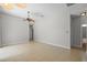 Neutral living room featuring tile floors, a ceiling fan, and an adjacent hallway leading to other rooms at 548 Casterton Cir, Davenport, FL 33897