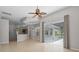 Bright living room featuring a ceiling fan, tile floors, and sliding glass doors to the screened-in patio at 548 Casterton Cir, Davenport, FL 33897