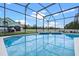Inviting in-ground pool surrounded by a screen enclosure and a well-maintained patio at 548 Casterton Cir, Davenport, FL 33897