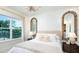 Stylish bedroom with ample natural light, decorative mirrors, and cozy bedding, creating a comfortable and inviting space at 5652 Nevis Ter, Kissimmee, FL 34758