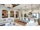 Open-concept living area with kitchen island, chandeliers, and expansive windows for great natural lighting at 5652 Nevis Ter, Kissimmee, FL 34758