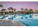 A resort-style pool is surrounded by lounge chairs, palm trees, and a bar for ultimate relaxation at 5652 Nevis Ter, Kissimmee, FL 34758