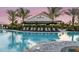 Community pool with a bar, lounge chairs and manicured landscaping at 5652 Nevis Ter, Kissimmee, FL 34758