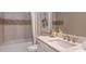 Bathroom features a bathtub with tile surround, vanity with white countertop, and mosaic accent tile at 5658 Nevis Ter, Kissimmee, FL 34758