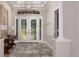 Inviting entryway featuring double doors with decorative glass, chandelier, and wood floors at 5658 Nevis Ter, Kissimmee, FL 34758