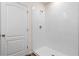 Modern bathroom featuring a sleek, tiled walk-in shower with contemporary fixtures and a white paneled door at 5896 Galloping Dr, Apopka, FL 32712
