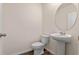 Powder room showcasing a pedestal sink, round mirror, and wood-look flooring at 5896 Galloping Dr, Apopka, FL 32712