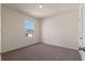 Clean bedroom featuring neutral walls, plush carpet, a window with a distant view, and a closed door at 5896 Galloping Dr, Apopka, FL 32712