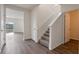 Bright entryway with wood-look flooring, staircase, and view into the adjacent living area at 5896 Galloping Dr, Apopka, FL 32712