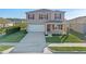 Charming two-story home featuring a two-car garage, landscaped lawn, and vibrant red shutters at 5896 Galloping Dr, Apopka, FL 32712