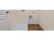 Functional laundry room with wood-look flooring, new hookups, and a utility sink base for appliances at 5896 Galloping Dr, Apopka, FL 32712