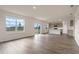 Open-concept living room with wood-look floors flowing into a modern kitchen and backyard access at 5896 Galloping Dr, Apopka, FL 32712