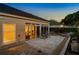 Backyard patio illuminated at twilight, featuring brick pavers, gravel landscaping, and the warmth glow coming from the interior at 5973 Chesapeake Park # 58, Orlando, FL 32819