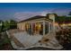 This backyard patio features a neutral brick paver patio, seating, rock details and lush landscaping at dusk at 5973 Chesapeake Park # 58, Orlando, FL 32819