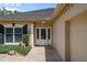 Close-up of a home's entry, showcasing a glass door, sidelights, and manicured shrubs at 5973 Chesapeake Park # 58, Orlando, FL 32819