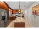 Modern kitchen features stainless steel appliances, granite counters, a central island and wood cabinetry at 5973 Chesapeake Park # 58, Orlando, FL 32819