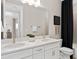 This bathroom features double sinks with white counters and cabinets plus modern fixtures at 6035 Blue View Way, St Cloud, FL 34771