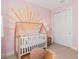 Bedroom with a hand painted sunburst mural accenting the light pink walls at 6035 Blue View Way, St Cloud, FL 34771