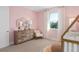 Light pink Bedroom featuring a dresser and rocking chair, lit by a sunny window at 6035 Blue View Way, St Cloud, FL 34771