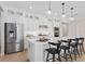 Bright kitchen with stainless steel appliances, white cabinetry, pendant lights, and hardwood flooring at 6035 Blue View Way, St Cloud, FL 34771