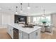 Open concept kitchen showcasing a large island with sink and view to the living and dining areas at 6035 Blue View Way, St Cloud, FL 34771