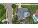Aerial view of a well-maintained home with a screened-in pool and lush landscaping with mature trees and sidewalks at 605 Macglenross Dr, Oviedo, FL 32765